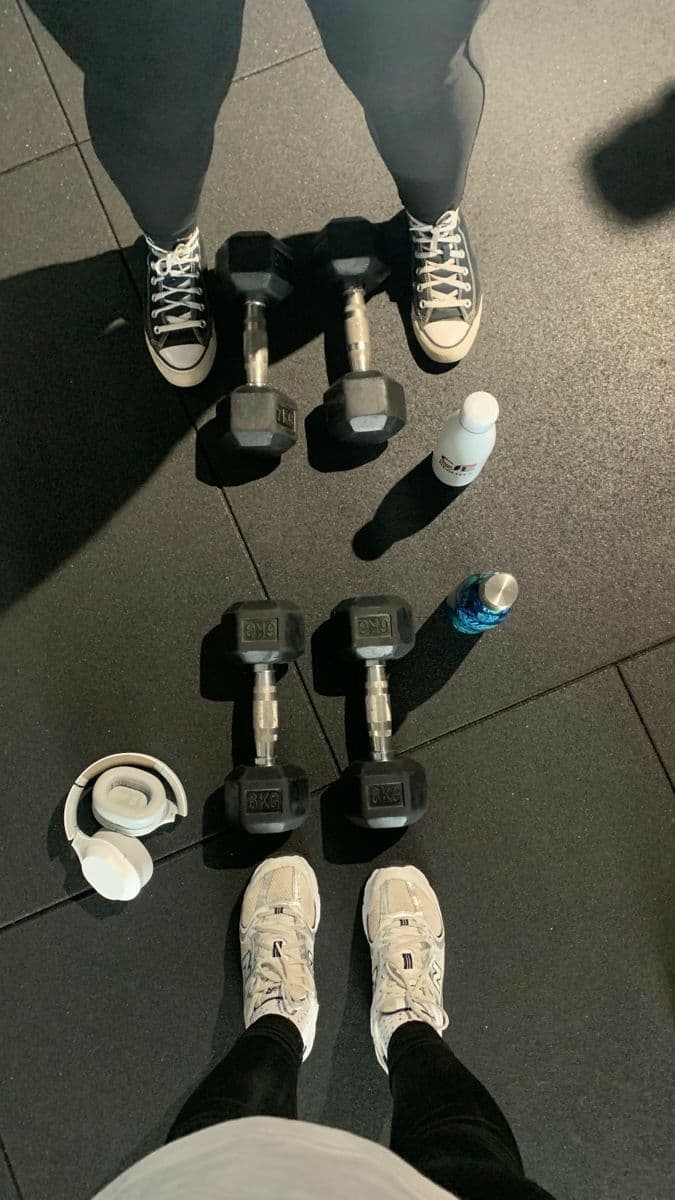 Dumbbells, headphones and trainers on a gym floor